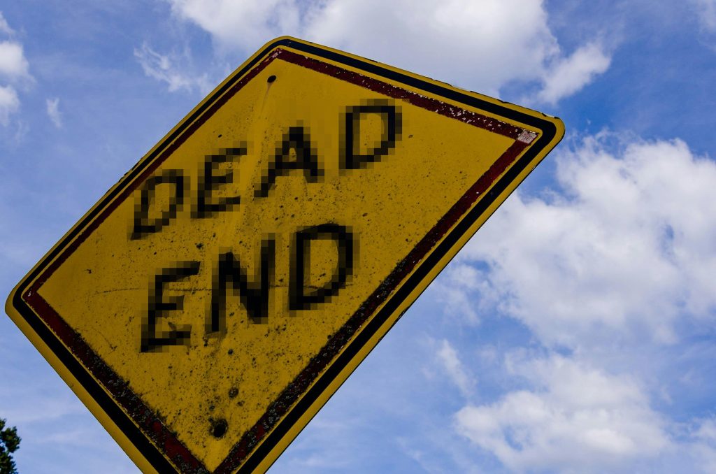 A road sign warning of a "Dead End", but the font is pixelated, while the rest of the image is clear.