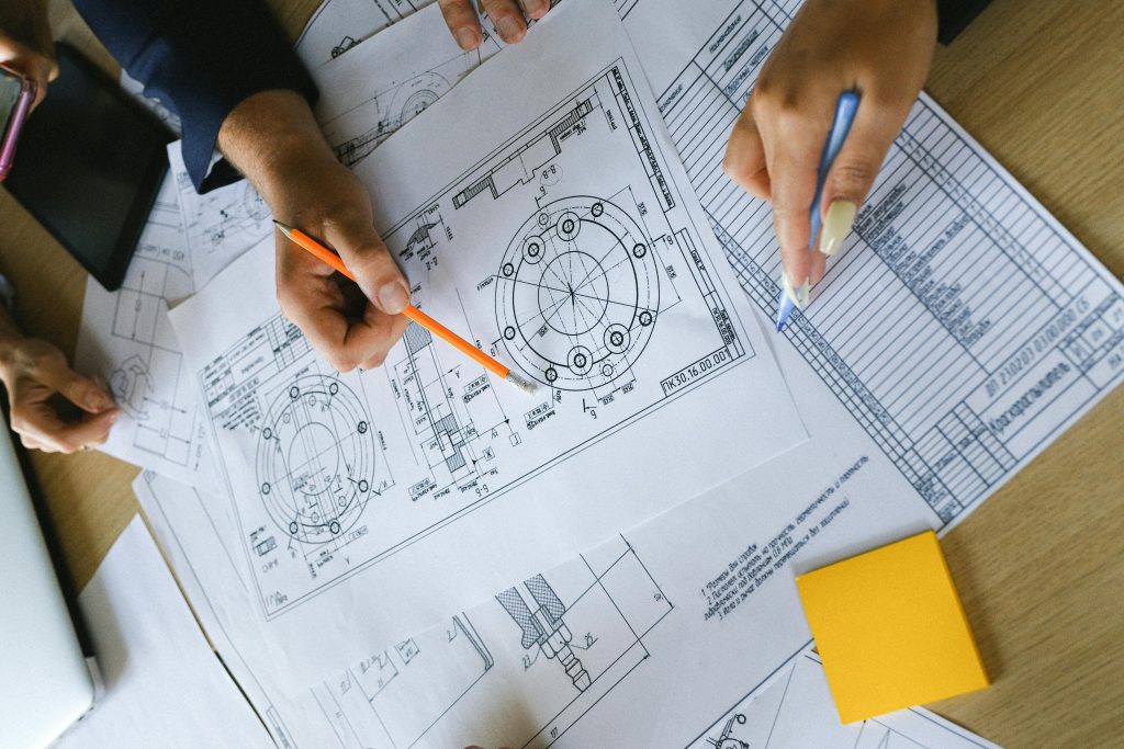 Photo by Anna Shvets: https://www.pexels.com/photo/business-partners-working-on-schemes-and-charts-on-papers-5324972/ A technical drawing showing equations and ratios is a great analogy for how vector images rely on equations and digital calculations to be able to scale vectors without distortion.